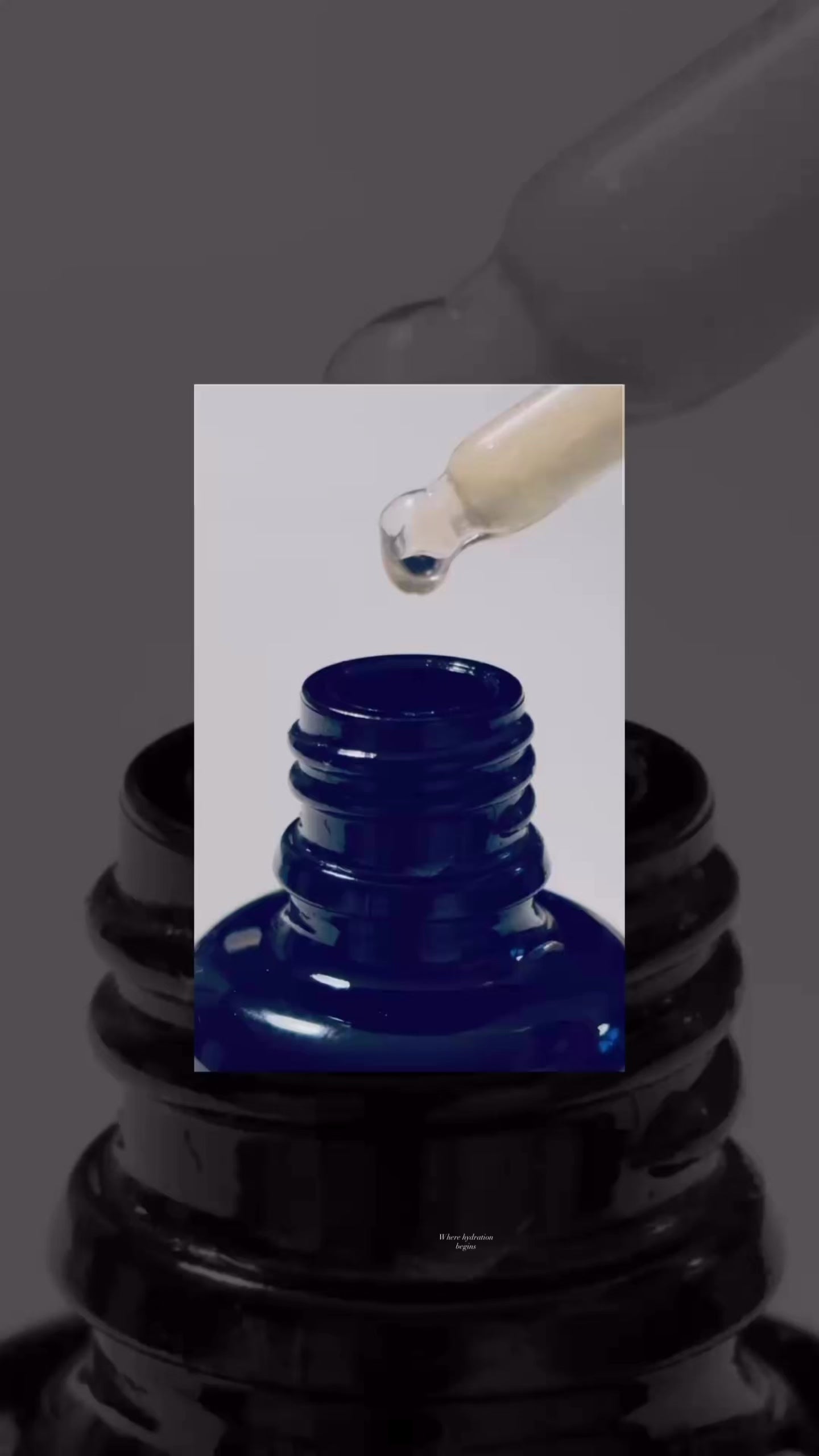 Load video: Slow motion serum drop falling into a skincare bottle